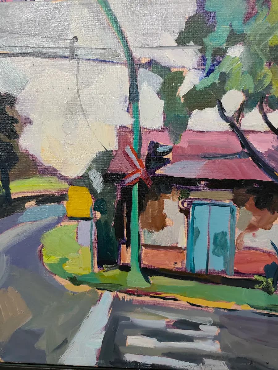 Una pintura vibrante de una escena urbana o suburbana, mostrando una esquina con un cruce de peatones y un poste de luz verde prominente. A la derecha, se observa una casa con tejado rojizo y una puerta azul brillante, rodeada de vegetación. La obra presenta pinceladas sueltas y colores vivos que capturan la luz de una manera dinámica.